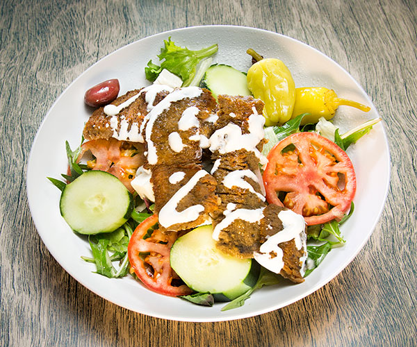 A gyro salad with white sauce
