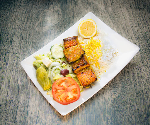 Salmon served with rice and an assorted vegetable salad